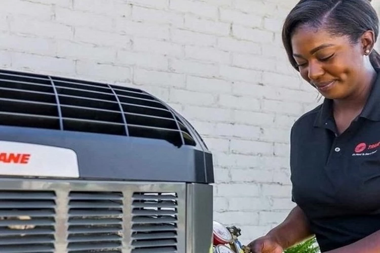 Picture of a femail HVAC Contractor taking freon or refrigerant readings from the AC unit